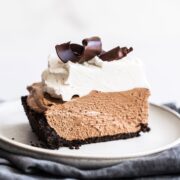 French Silk Pie features an Oreo cookie crust, rich and creamy chocolate filling, and is topped with homemade whipped cream and chocolate shavings! No raw eggs. Perfect holiday recipe!