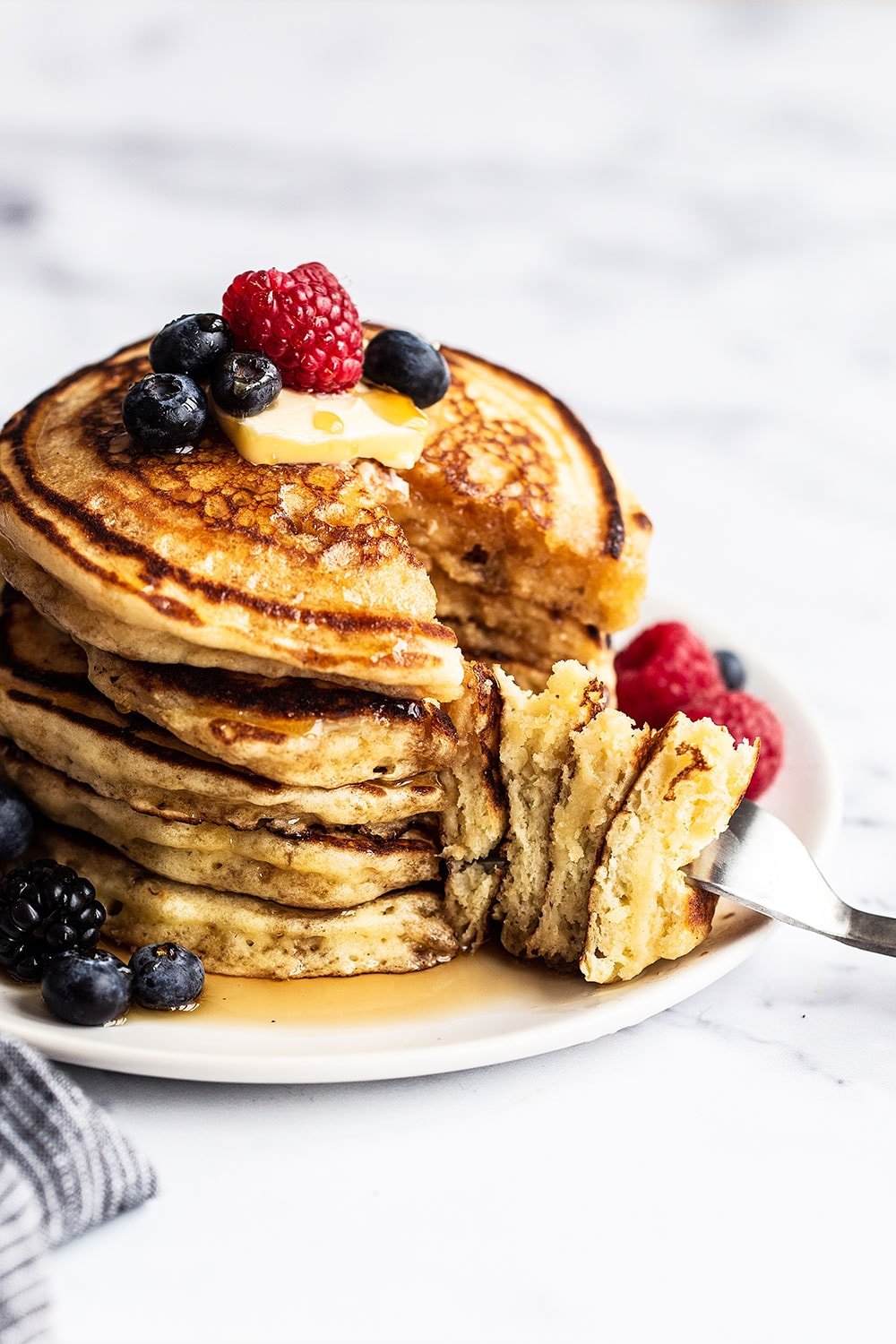 Stack of pancakes cut into with a fork. The perfect Easter brunch option.