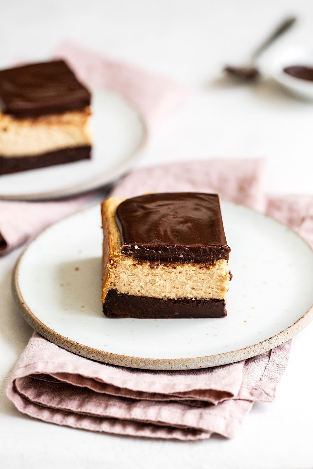 Peanut butter cheesecake bars with brownie crust on plates