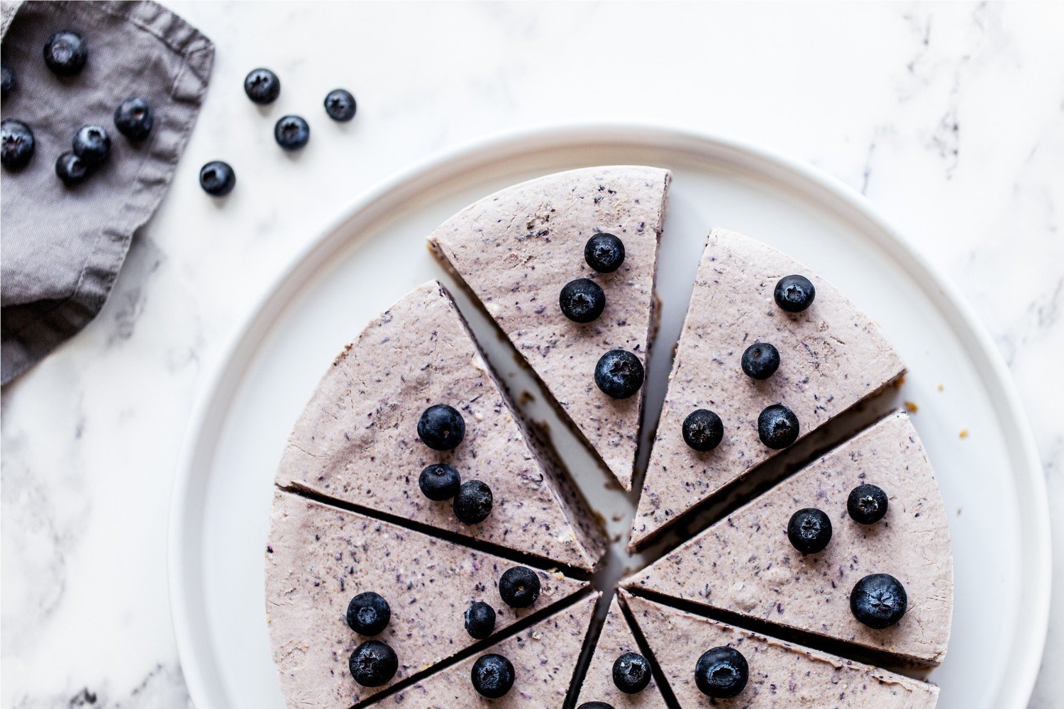 the whole pie cut into slices with a few fresh blueberries scattered on top.