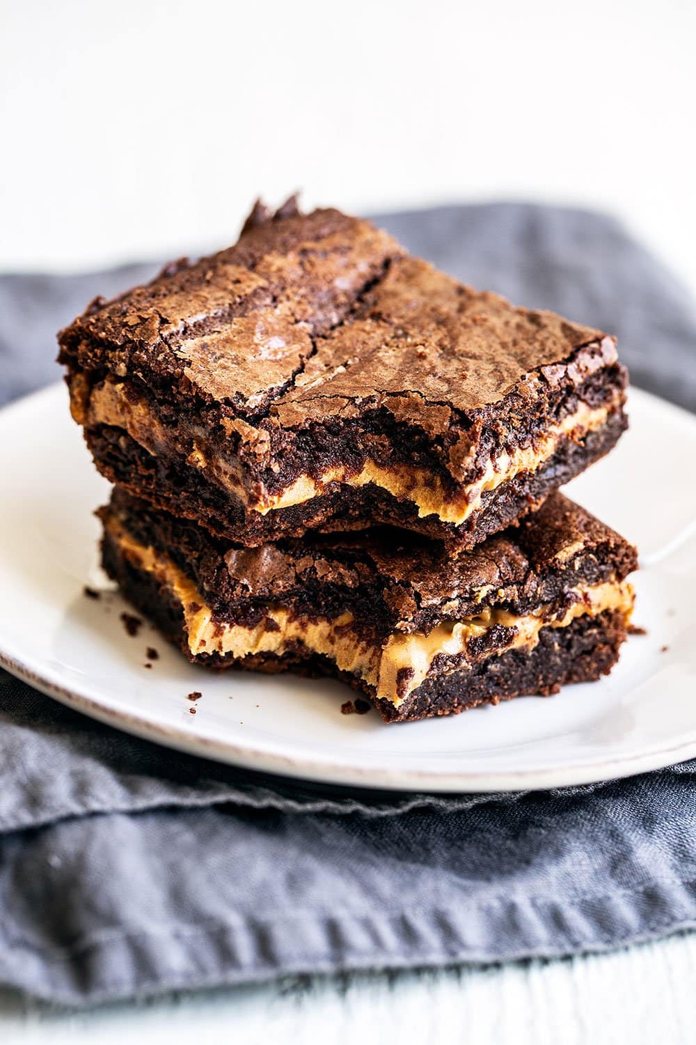 Peanut butter stuffed brownies stacked on top of each other on a plate 