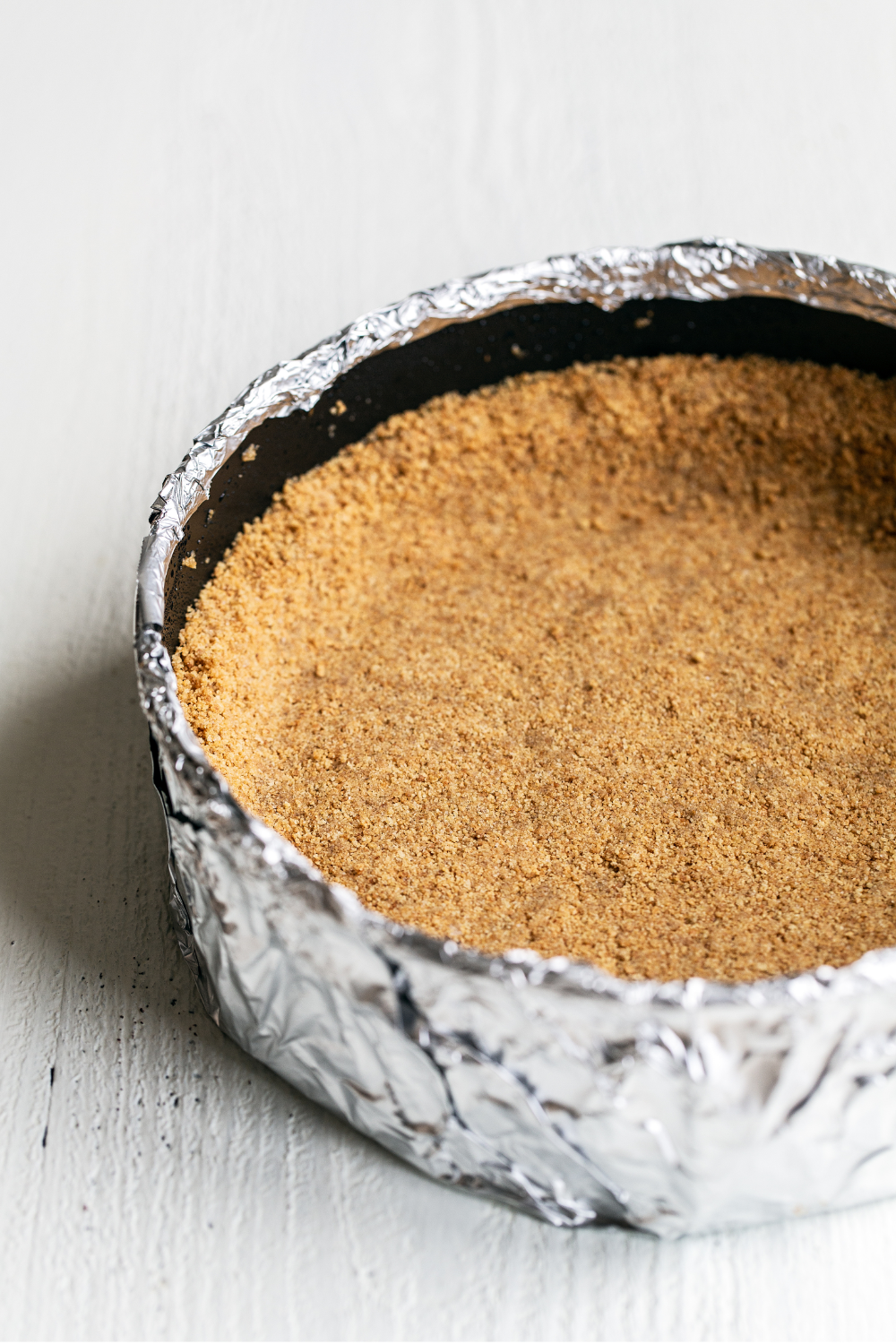 the graham cracker crust in its pan, ready to be filled with cheesecake.