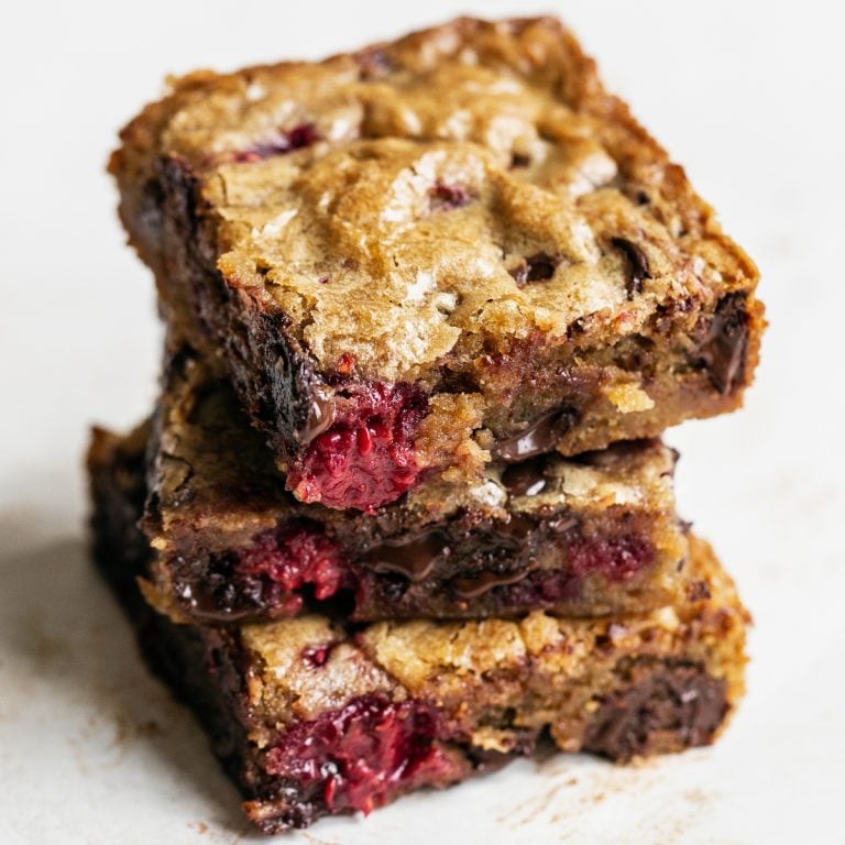 Stack of three homemade raspberry dark chocolate blondies.