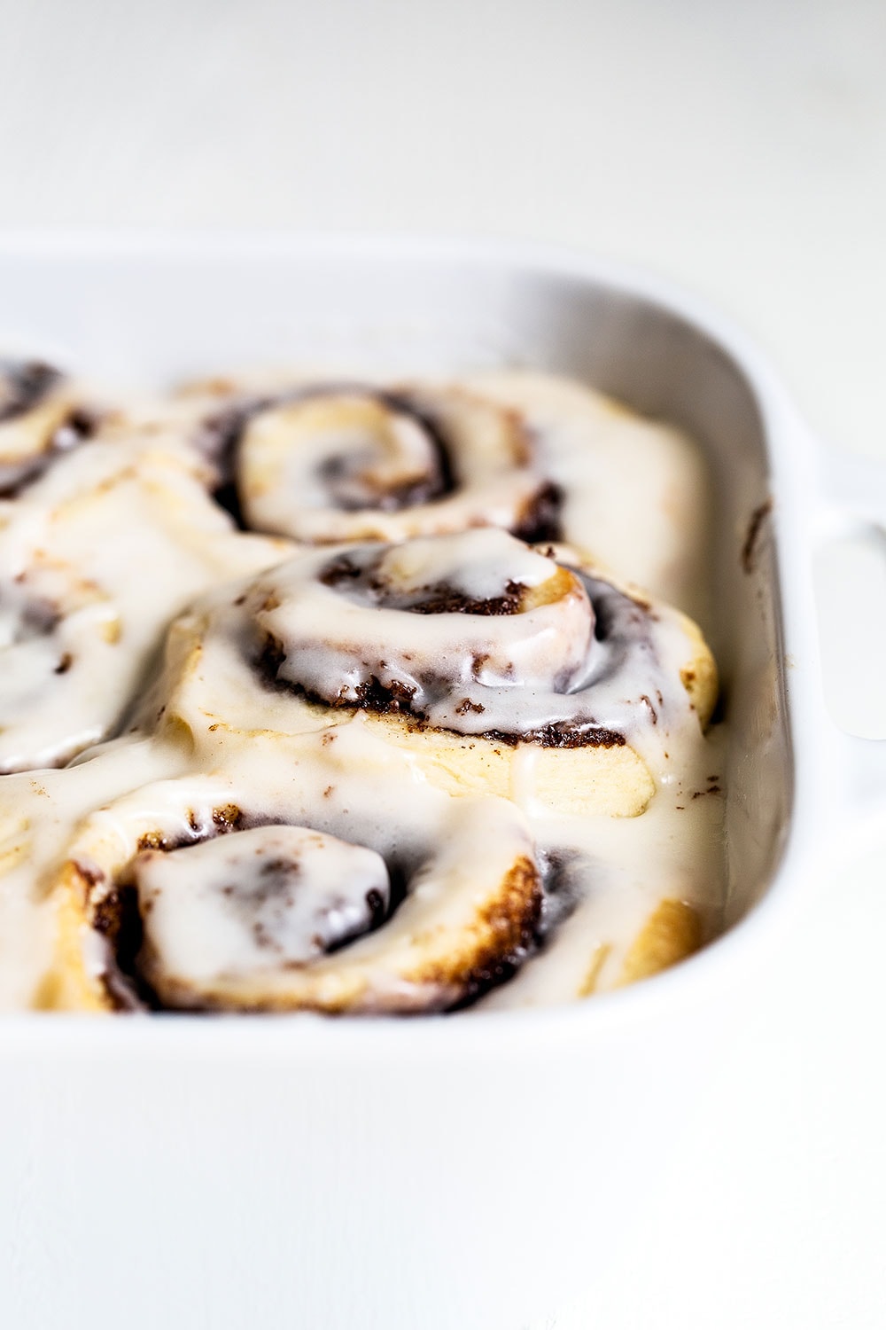 Cinnamon rolls in a baking dish with icing on top