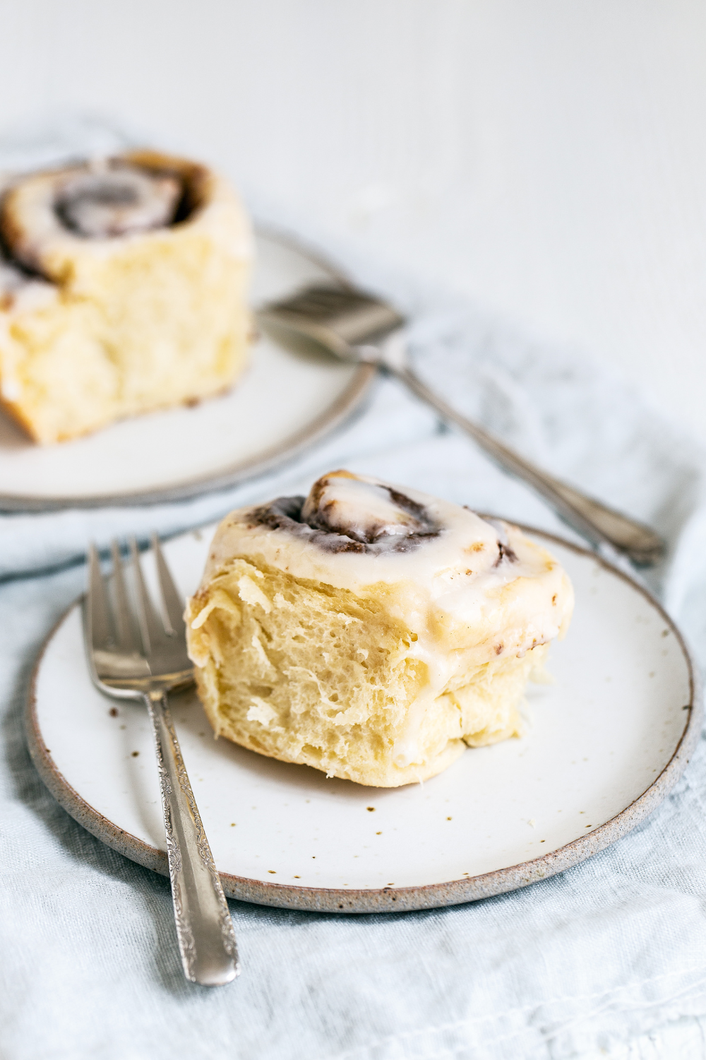Gooey Cinnamon Rolls on plates with forks, ready to be served