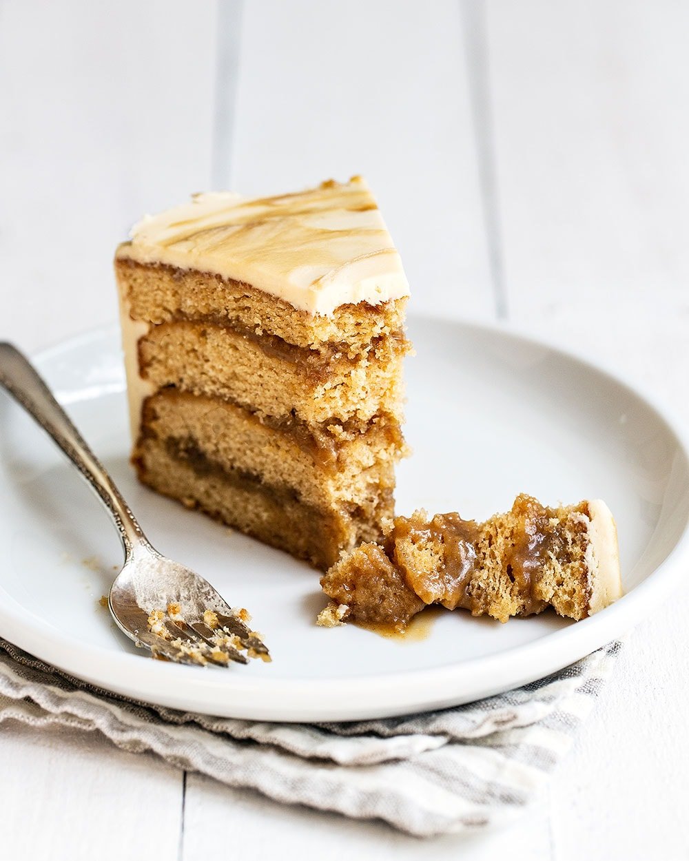 Ultra rich, tender, and moist Butterscotch layer cake slice on a plate with a bite taken out