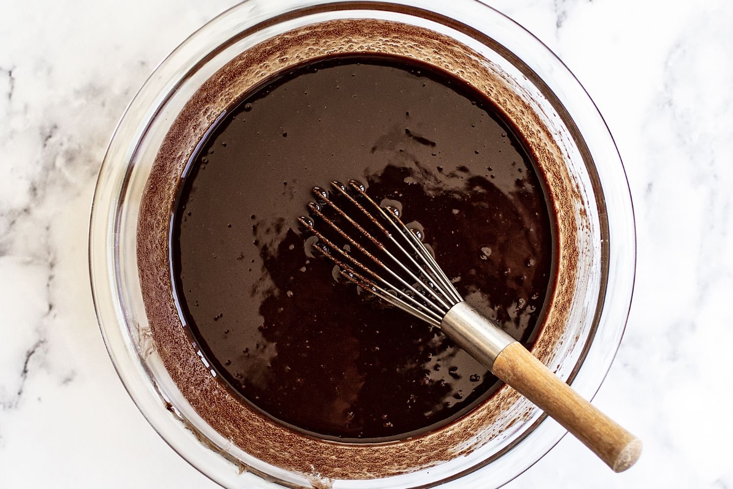 Kom met brownie-beslag en een garde.