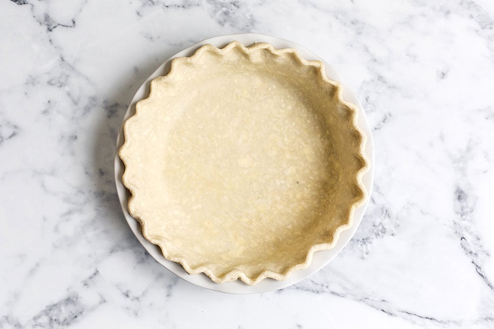 Homemade all butter pie crust in pie tin ready to be par baked