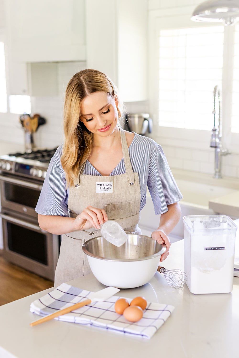 Tessa in the kitchen pouring flour into a bowl