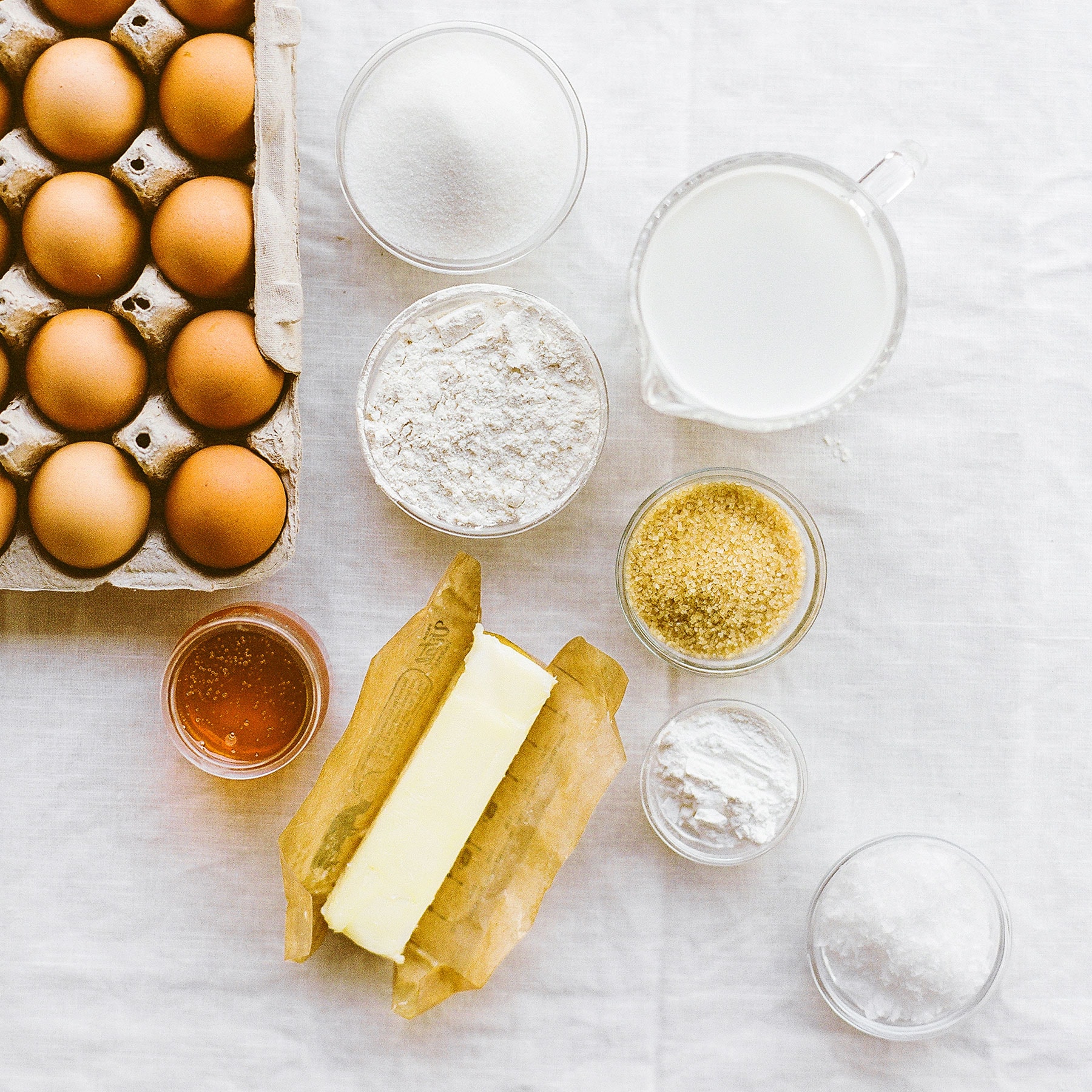 Eggs, butter, flour, sugar, and other baking ingredients on a table
