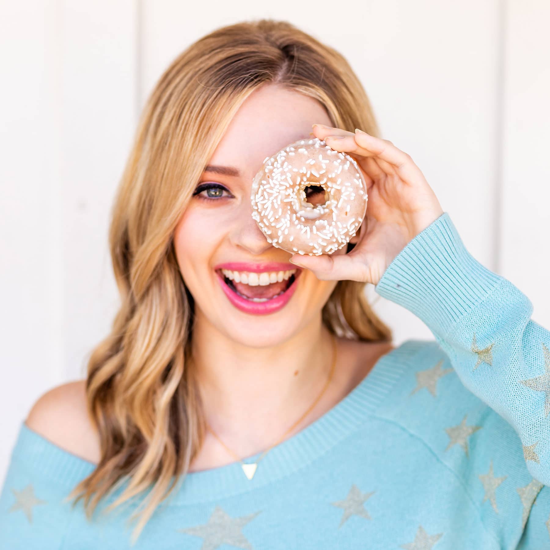 Photo of Tessa holding a vanilla donut