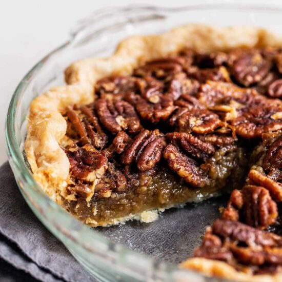 Pecan pie in pie plate with a slice removed