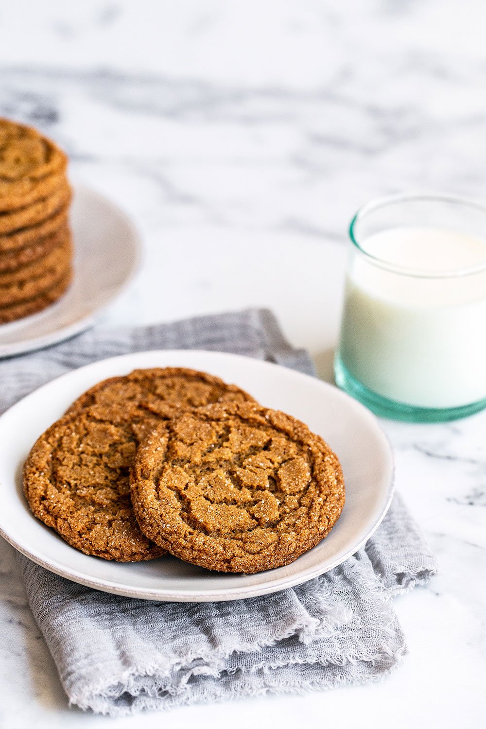 crispy, crunchy gingersnaps on a plate, beside a cold glass of milk