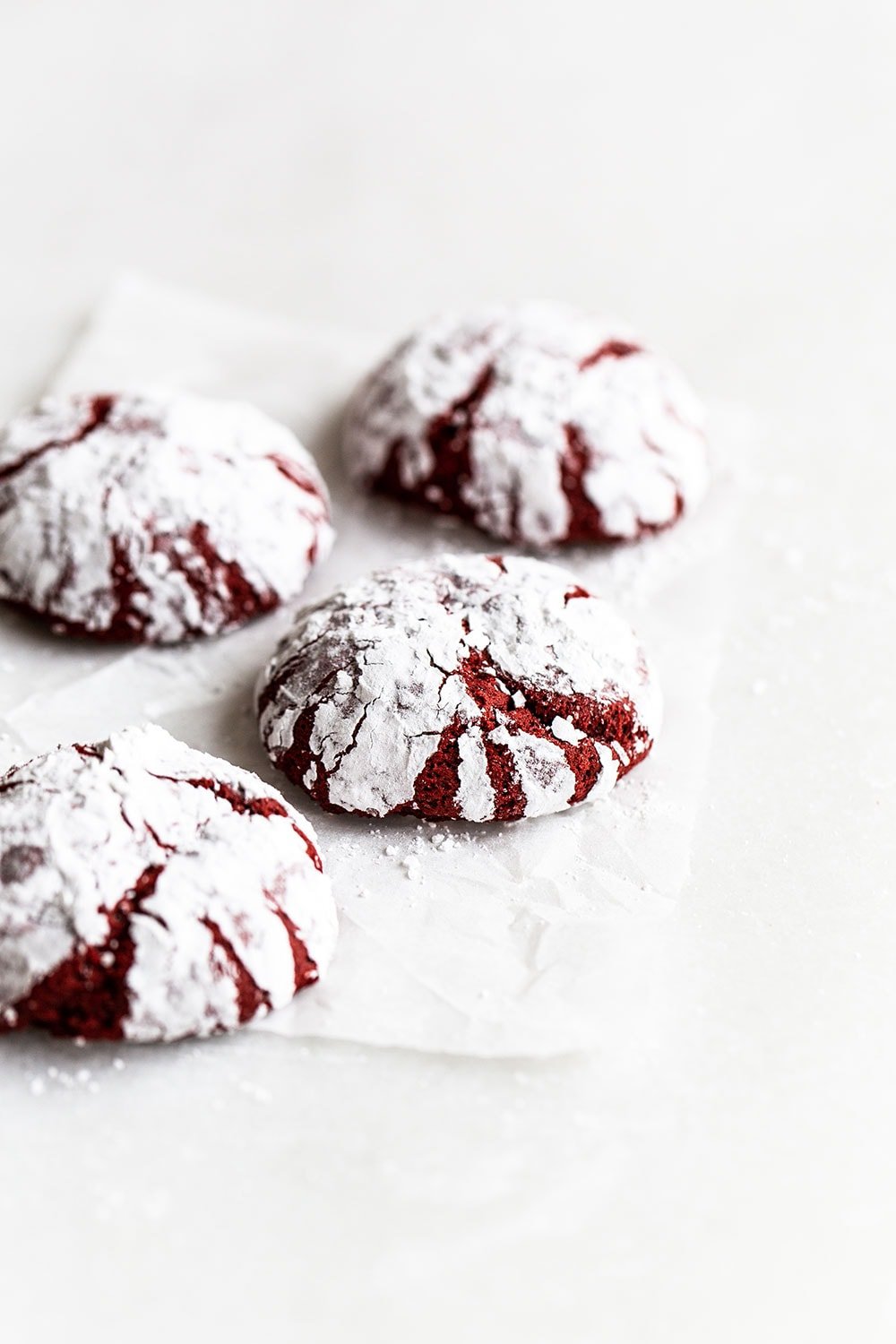 Easy red velvet crinkle cookies on a piece of parchment paper