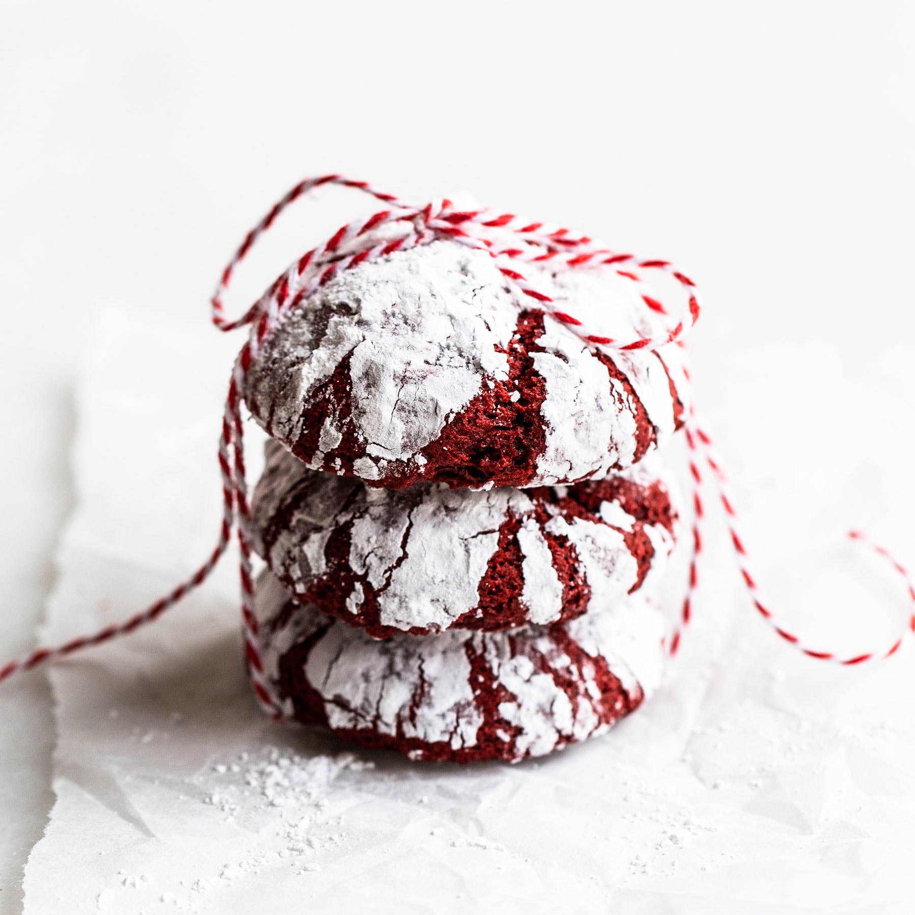 stack of red velvet crinkle cookies with bakers twine
