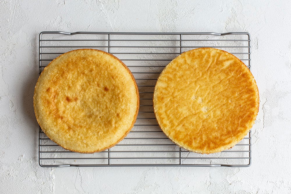 Homemade yellow cake layers cooling on rack