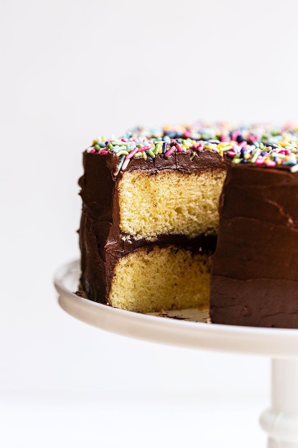 Yellow Layer Cake with Chocolate Frosting on a cake stand