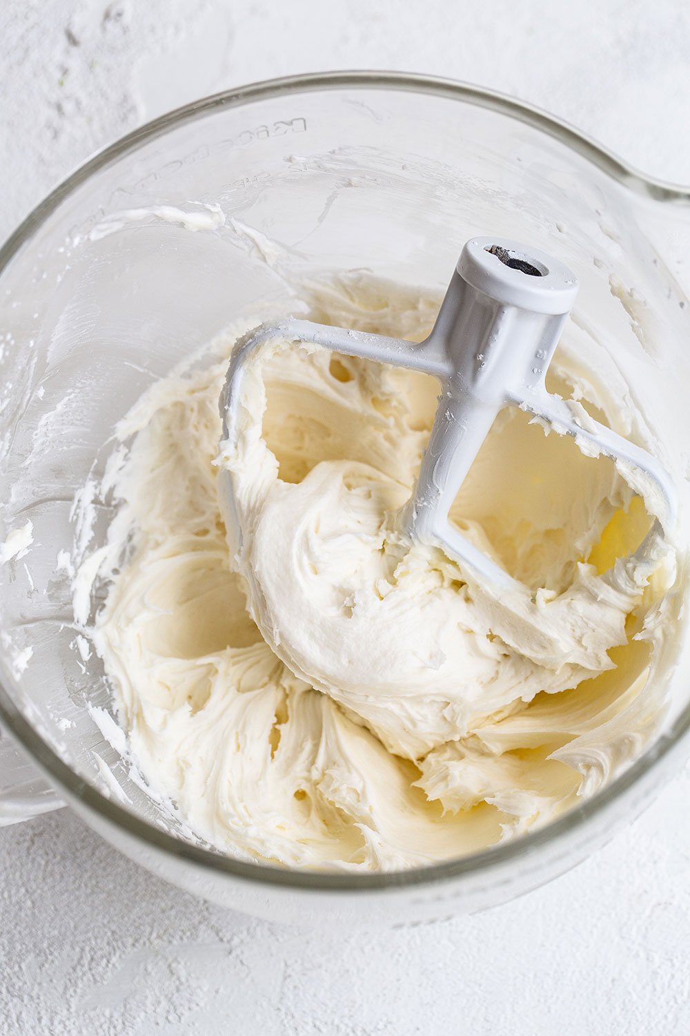 Mixing bowl of coconut buttercream frosting for cupcakes