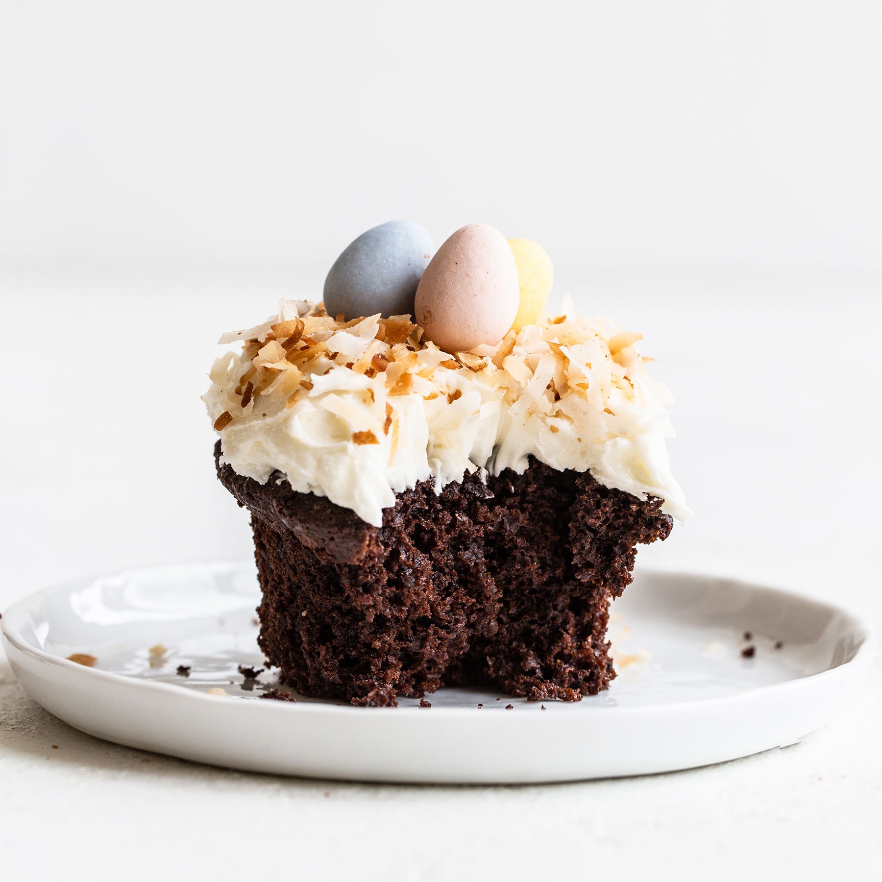 Easter Chocolate Coconut Cupcake on a plate with a bite taken out