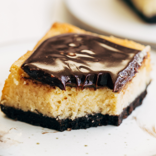 a slice of Bailey's Cheesecake Bars on a plate, ready to serve.