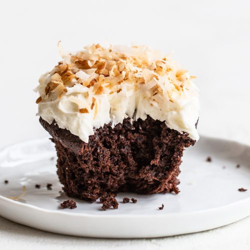 Chocolate coconut cupcake on a plate with a bite taken out