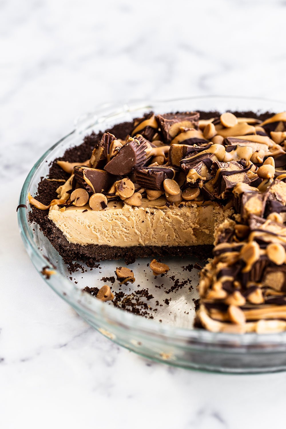 Simple homemade peanut butter pie in glass pie pan with slices already cut out