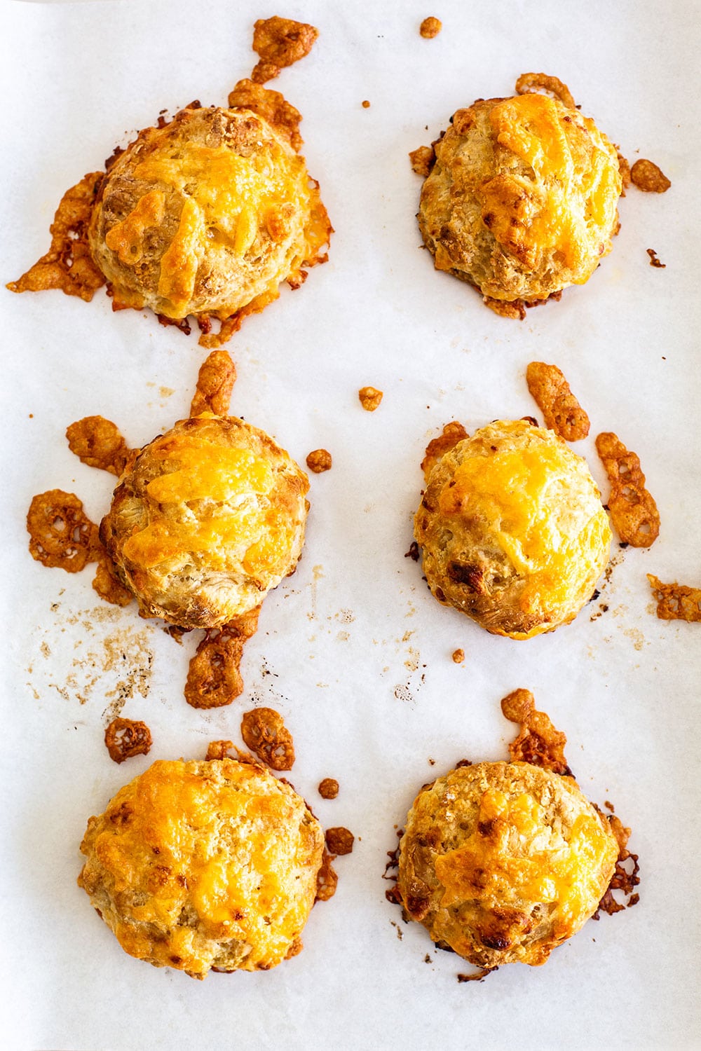Crispy, flaky, fluffy golden cheddar biscuits on a baking sheet