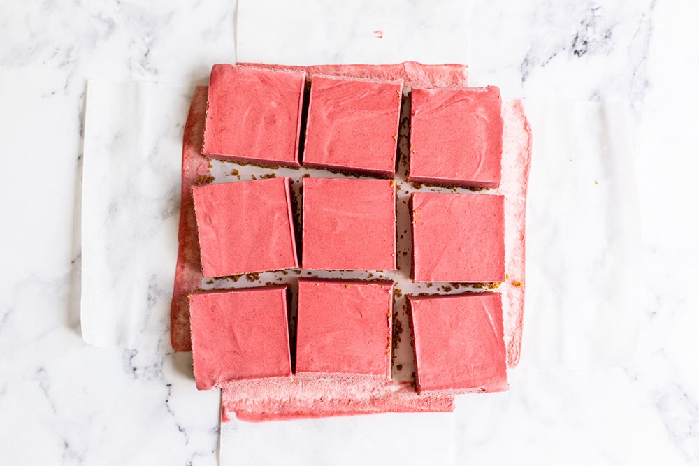 Tray of no bake strawberry cheesecake sliced into perfect squares