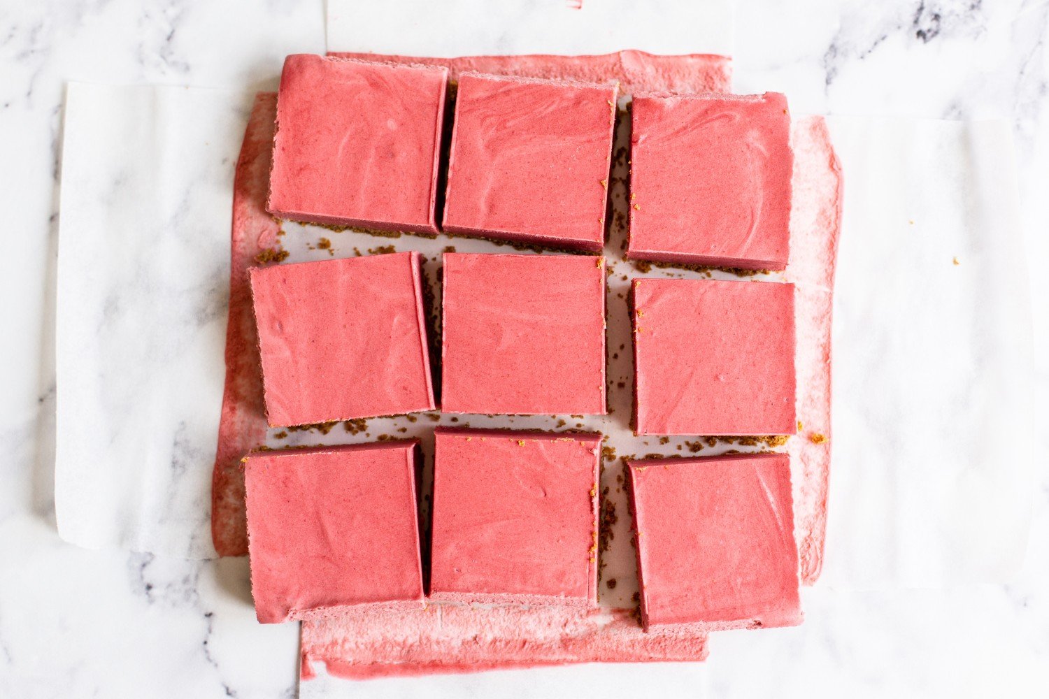 a pan of strawberry cheesecake bars cut into 9 slices. 