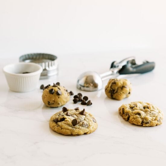 Cookie dough and baked cookies on a marble counter