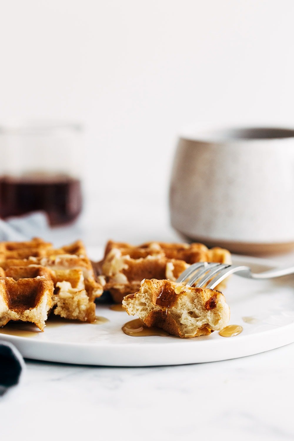 Homemade waffle on a fork with maple syrup