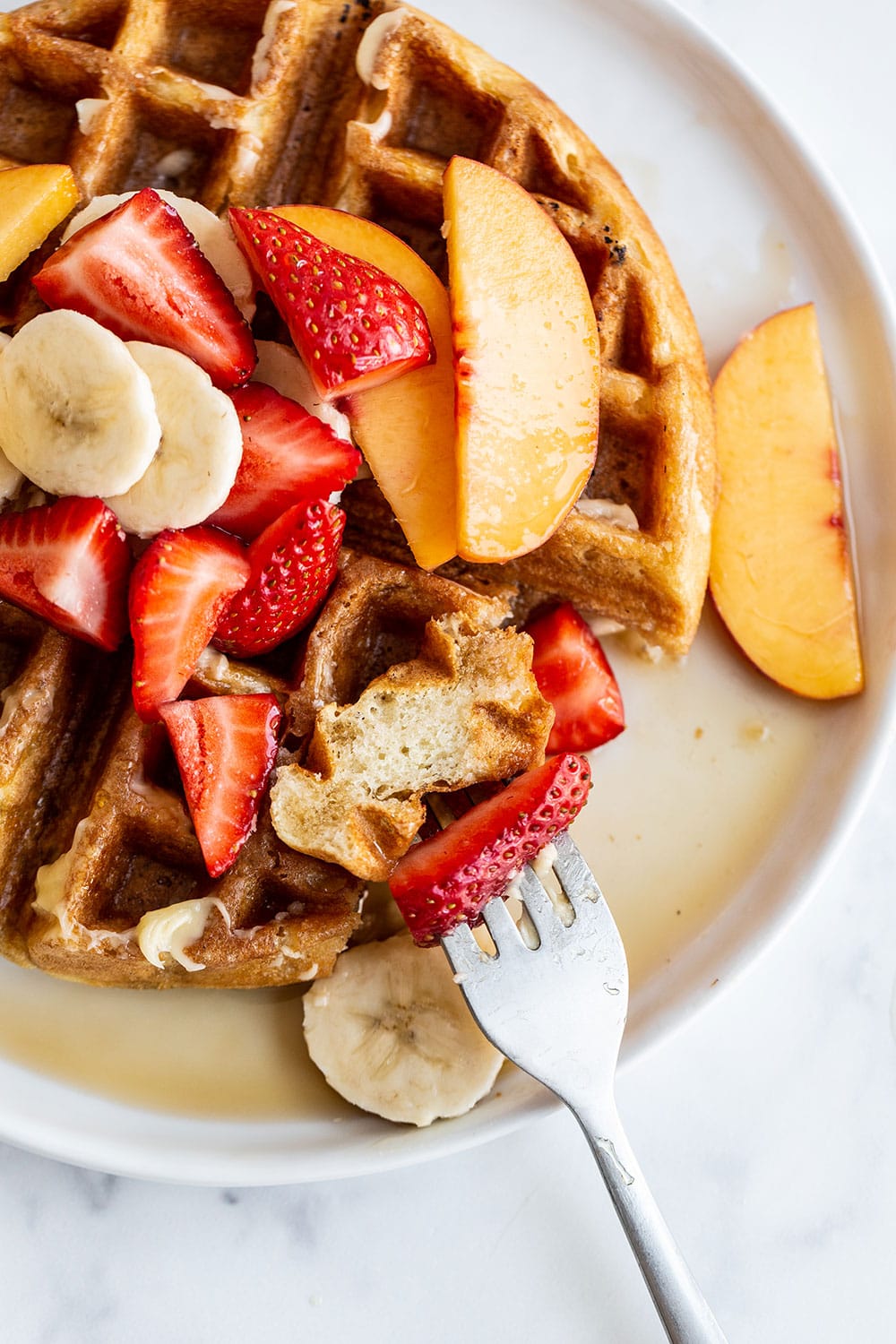 Waffle on a plate with maple syrup and fresh fruit for Easter brunch