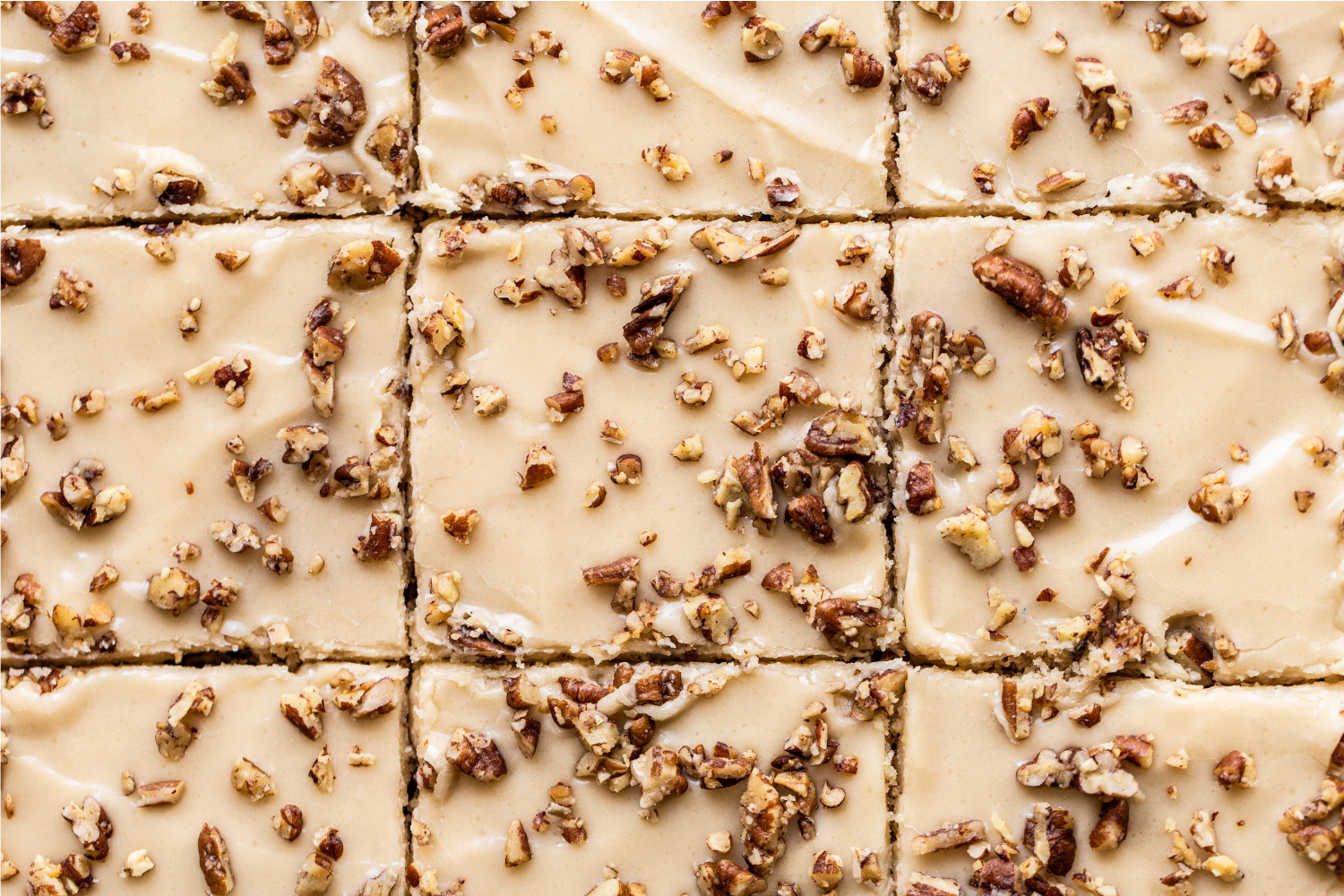 iced cake topped with buttery pecan pieces, sliced up.