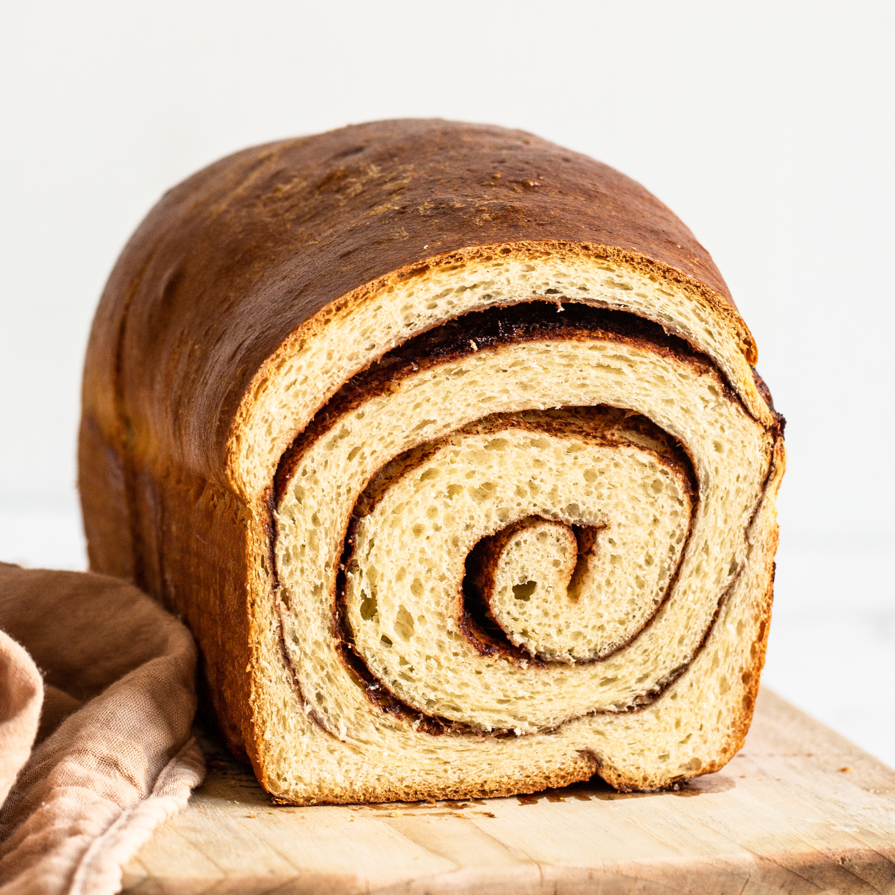 loaf of cinnamon swirl bread cut into so we can see the beautiful swirl.