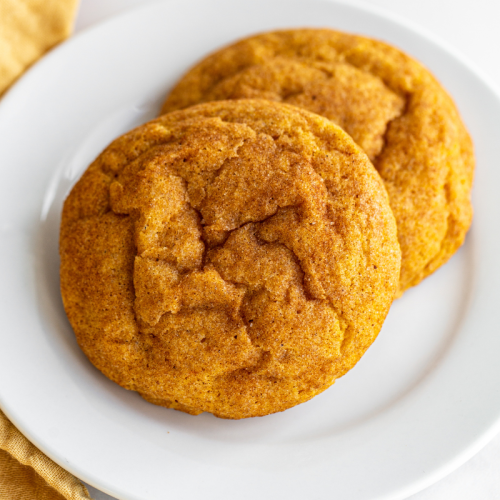 two pumpkin snickerdoodles sitting on a white plate