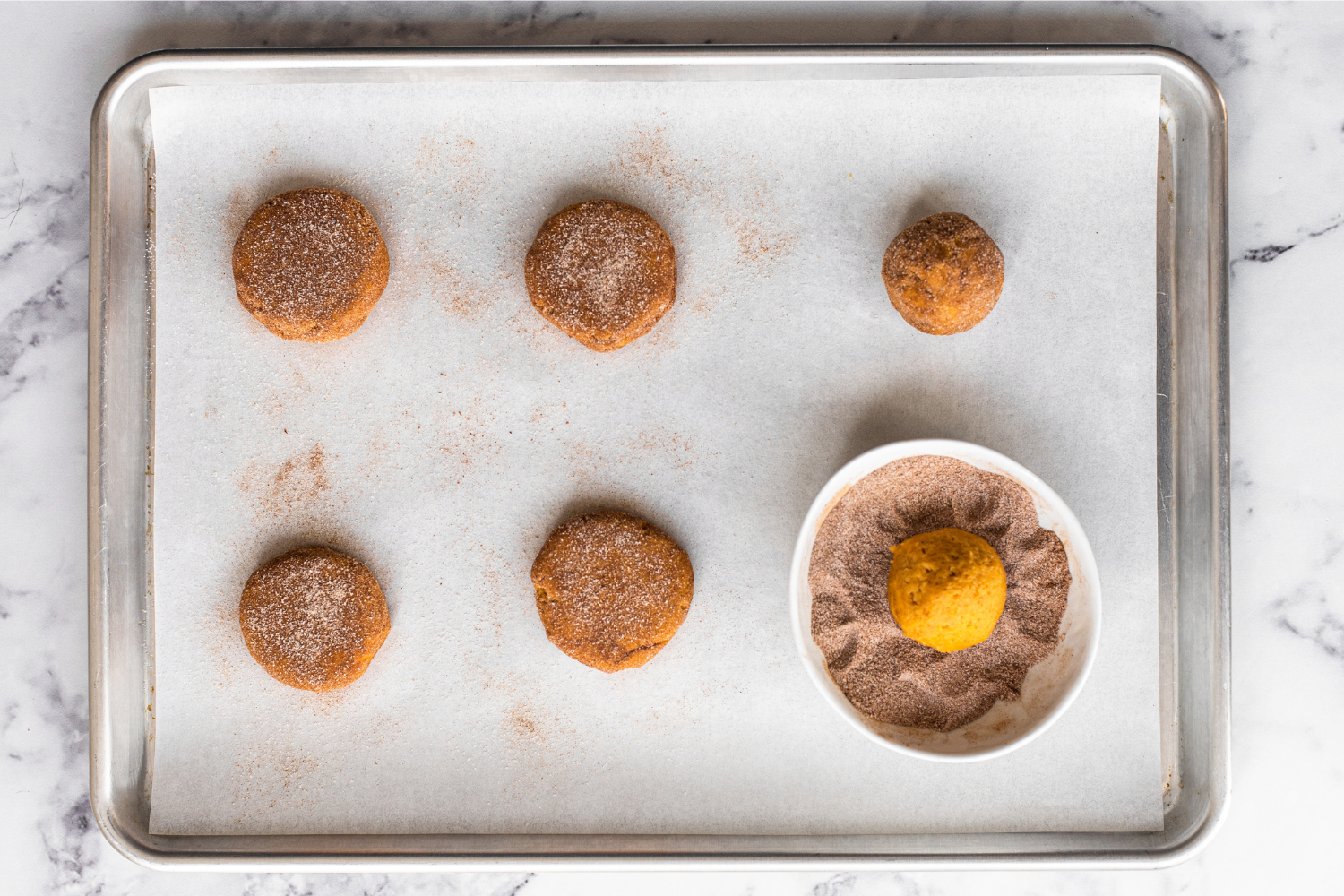 pumpkin snickerdoodle cookies on a baking sheet, ready to bake