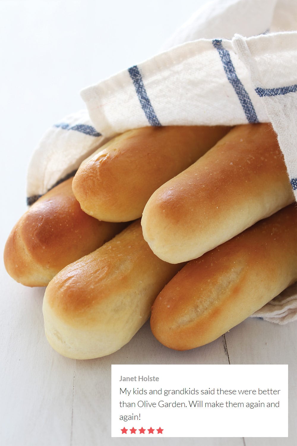 copycat olive garden breadsticks wrapped in a white and blue cloth