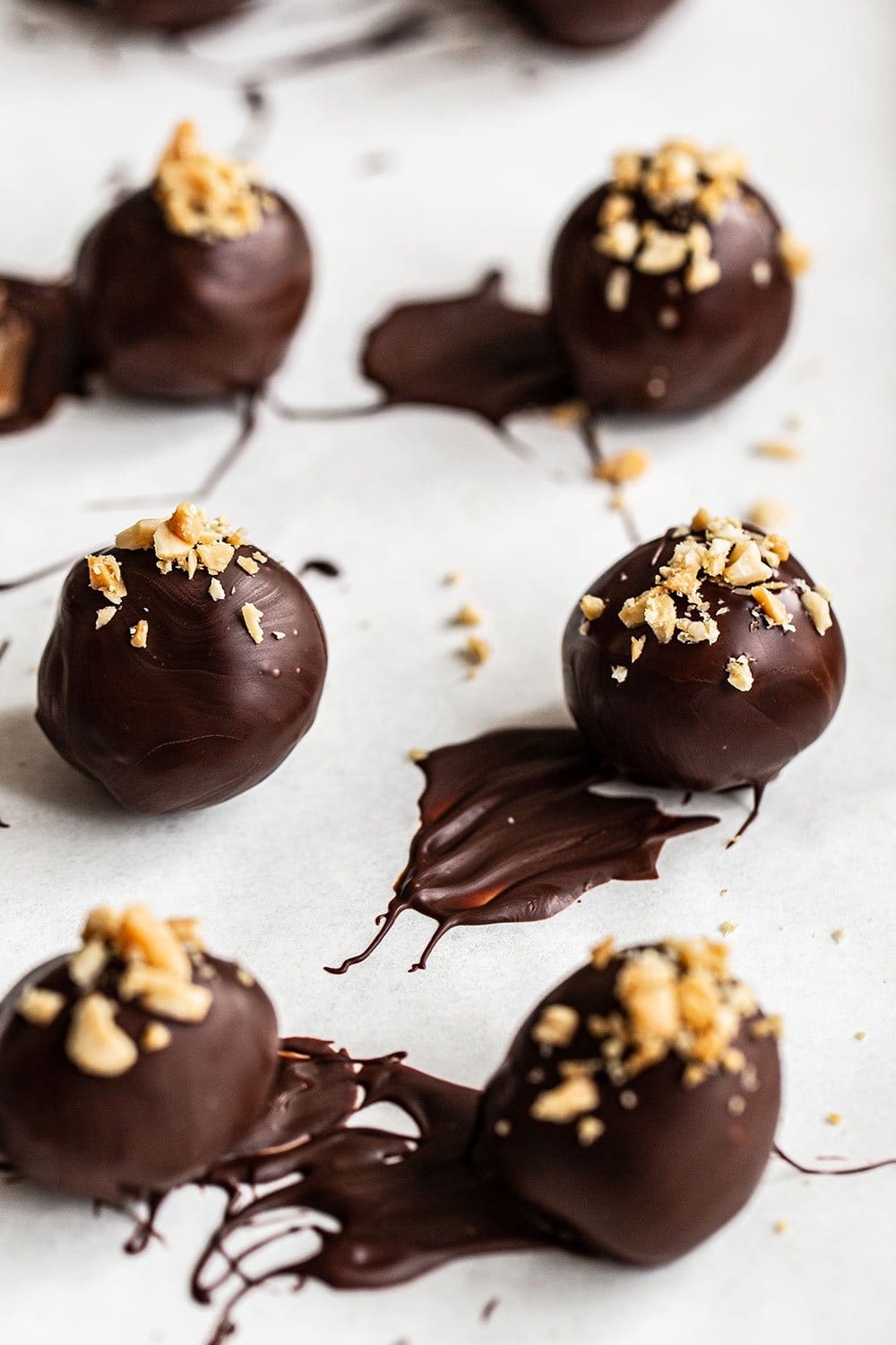 easy homemade chocolate peanut butter whiskey truffles with peanuts sprinkled on top. Such a fun truffle for your St. Patrick's Day dessert needs. 