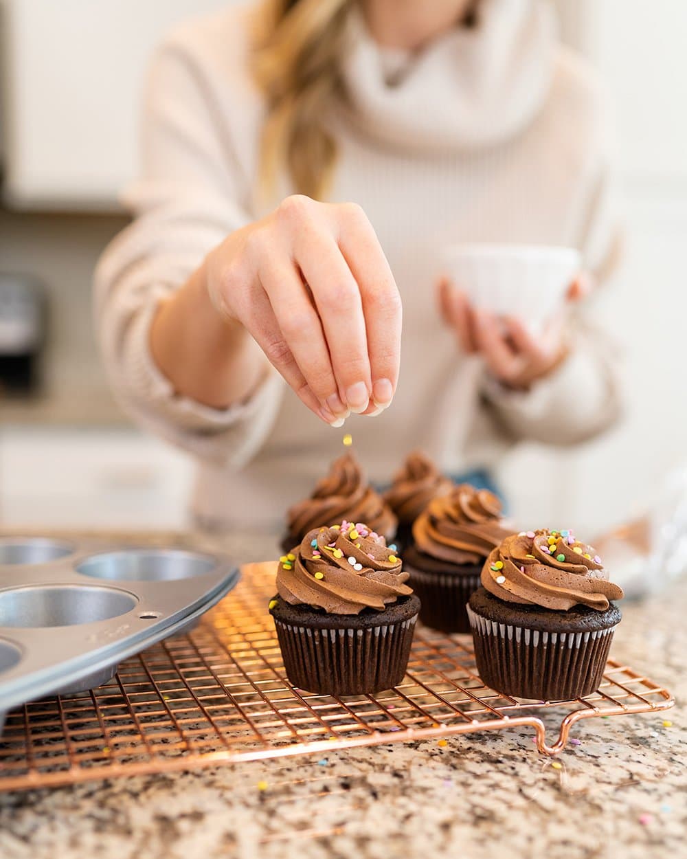 decorating chocolate cupcakes with sprinkles