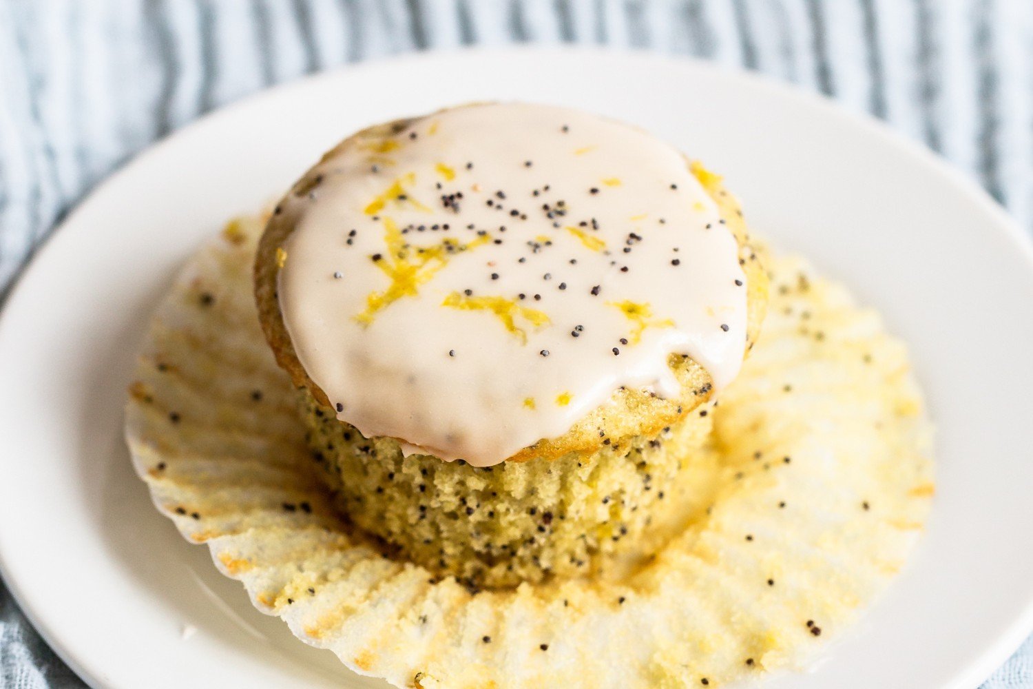 a lemon poppy seed muffin on a white plate.