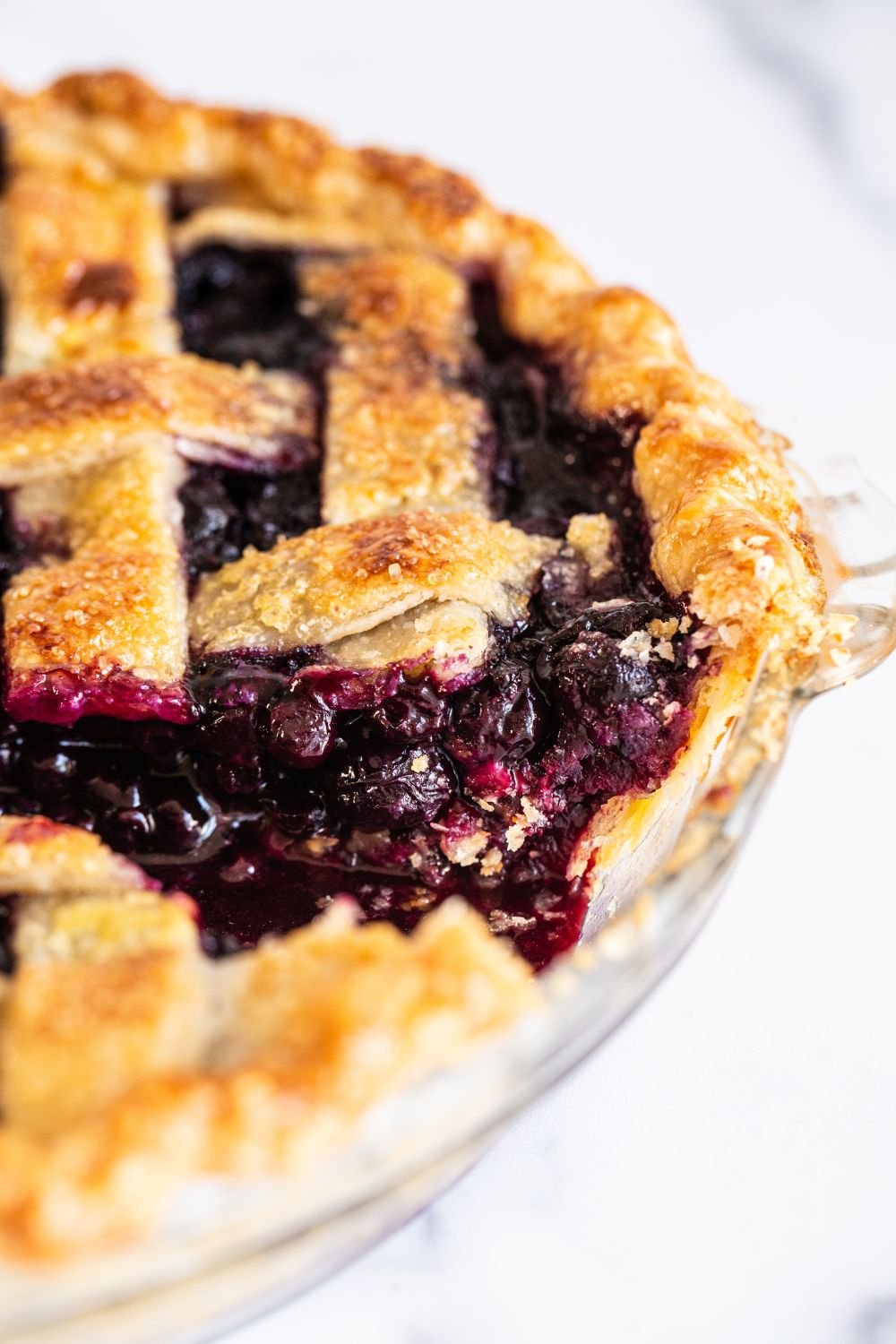 baked blueberry pie with a slice taken out.