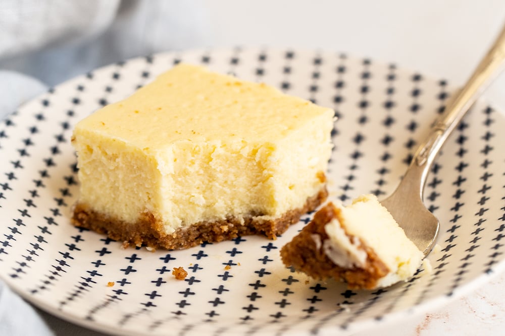 square of cheesecake on a plate with a fork