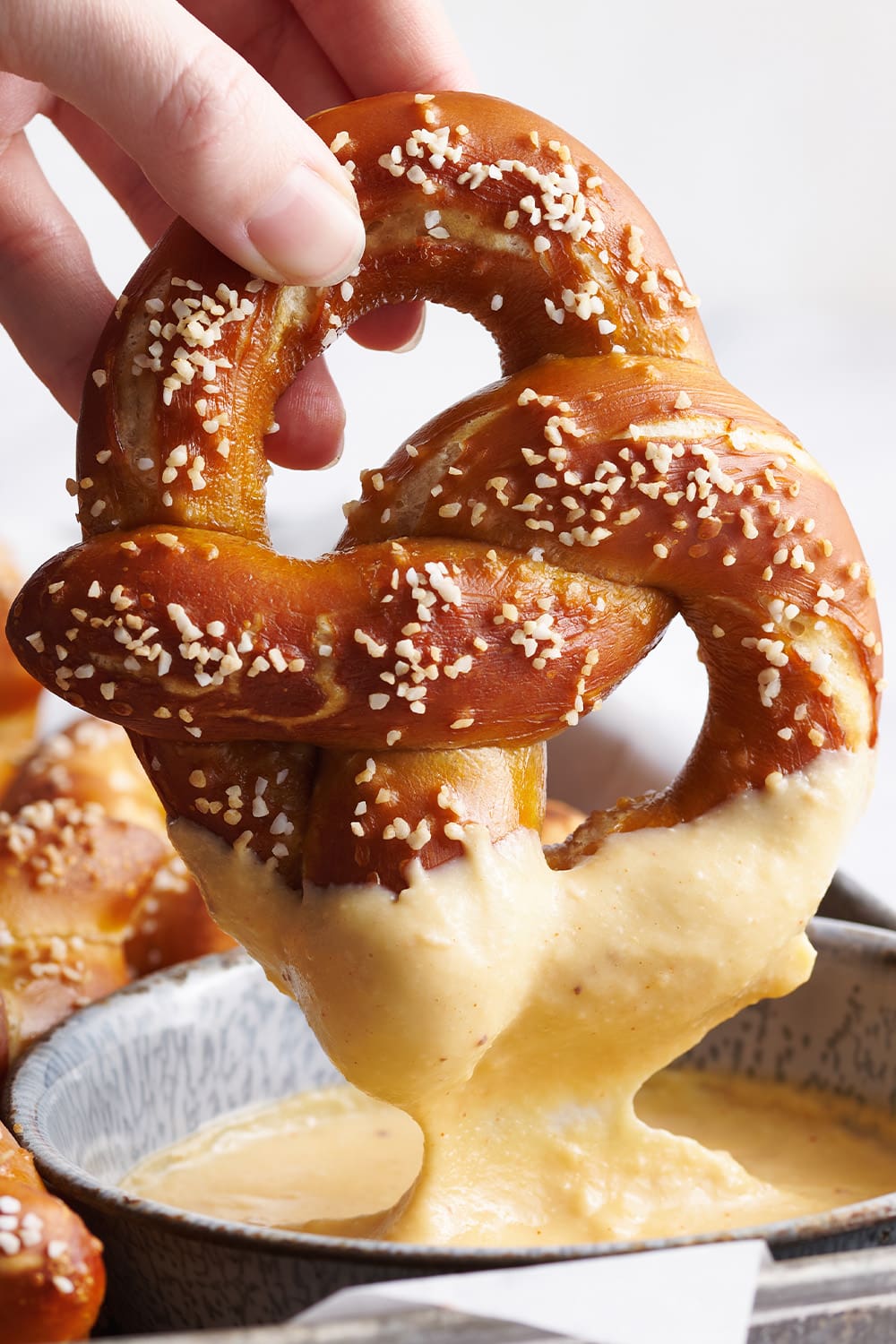 soft pretzel being dunked into easy beer cheese dip recipe