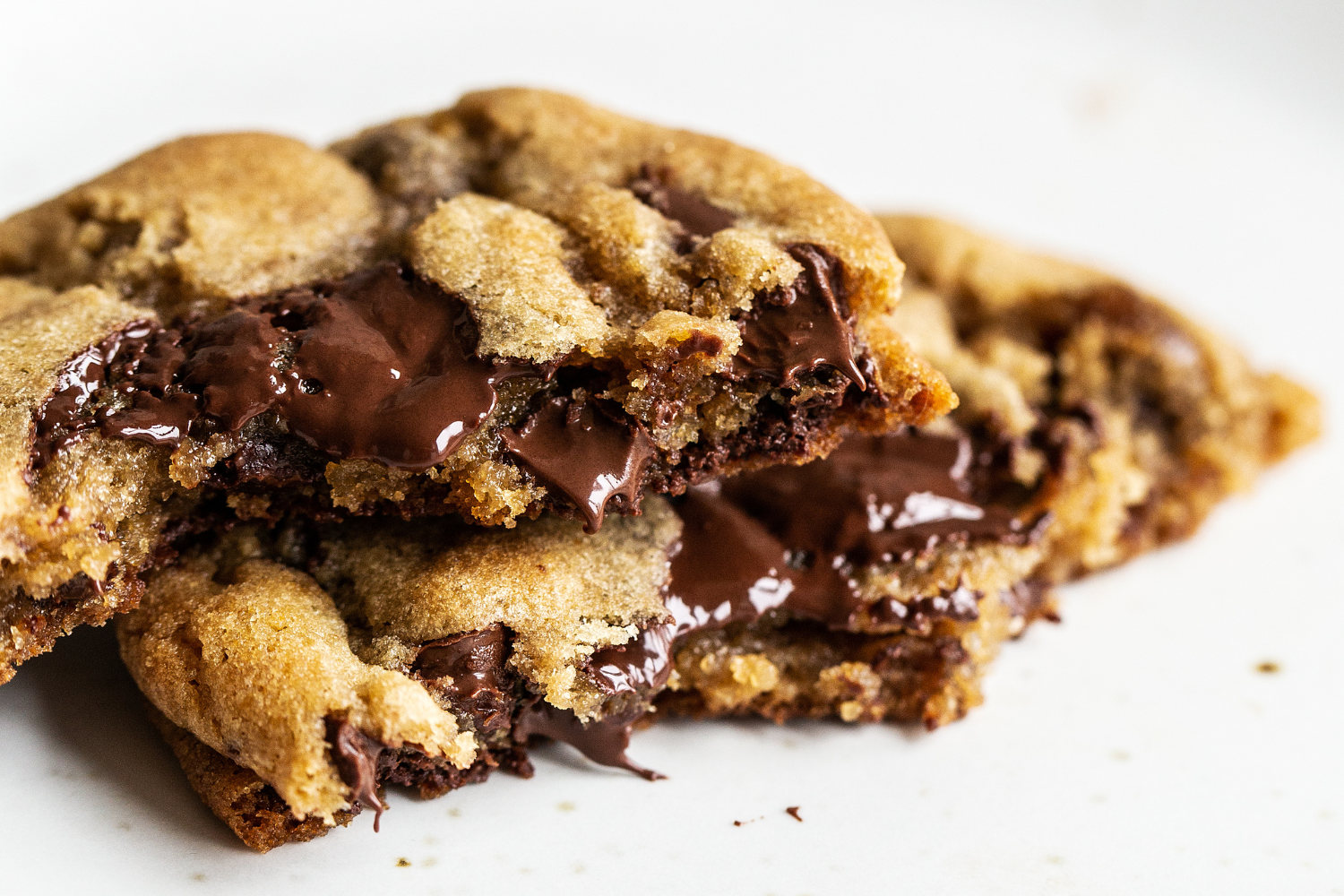 a Brown Butter Chocolate Chip Cookie broken in half, with the gooey chocolate melting 