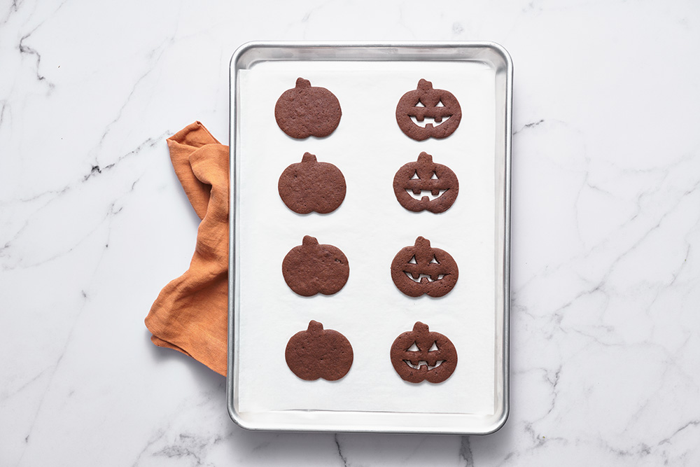 the jack-o-lantern chocolate sugar cookies on a baking tray, ready to bake