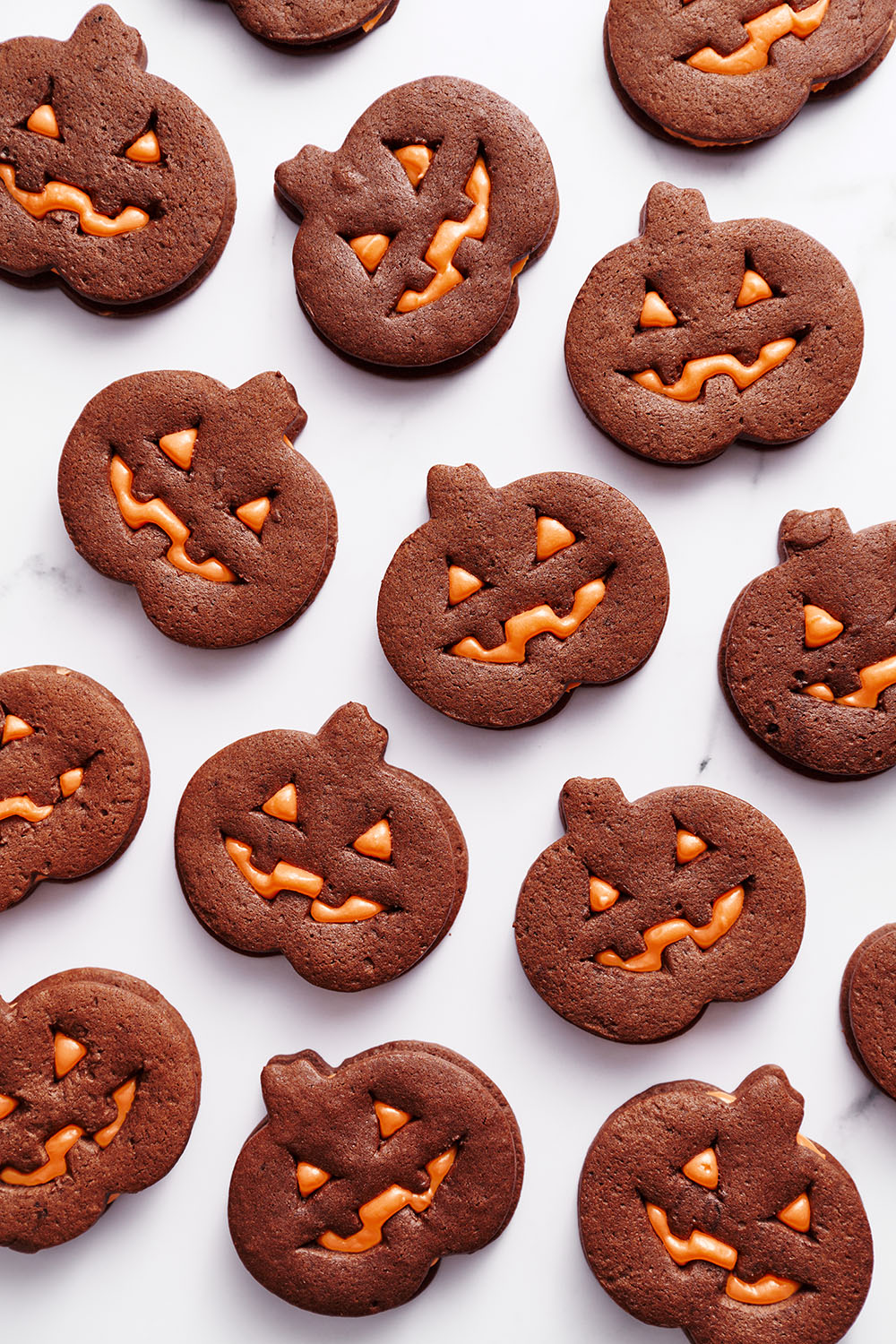 several Jack-o'-Lantern Chocolate Sugar Cookies on a white background