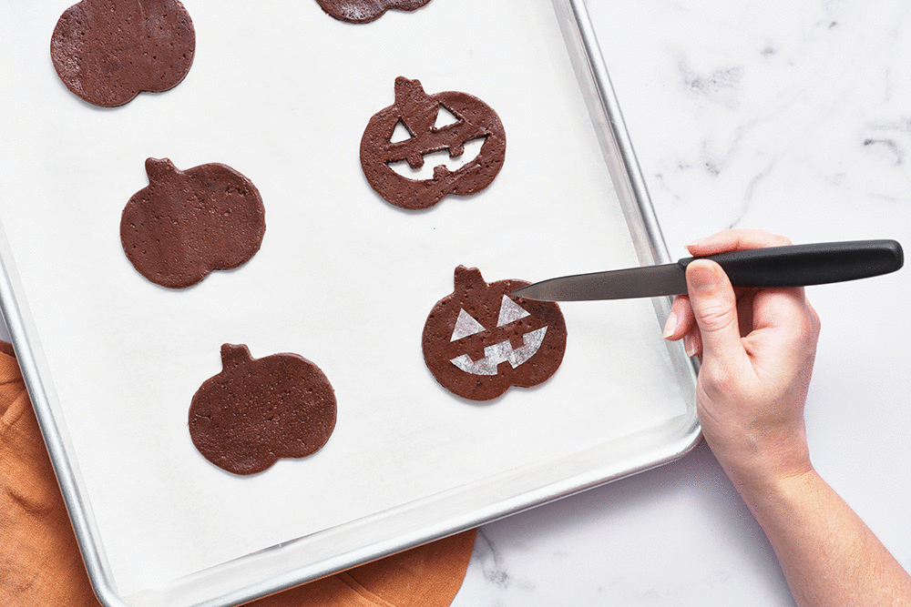 gif showing how to cut out the jack-o-lantern faces from the rolled-out cookie dough