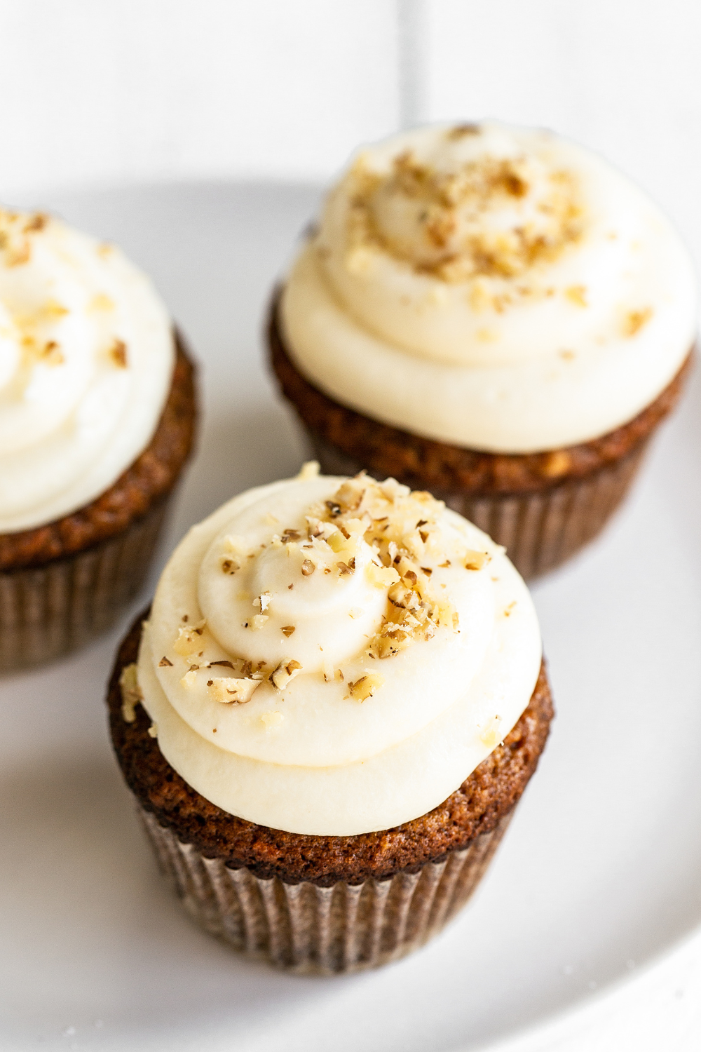 perfect Carrot Cake Cupcake with cream cheese frosting, with chopped walnuts on top, ready to serve.