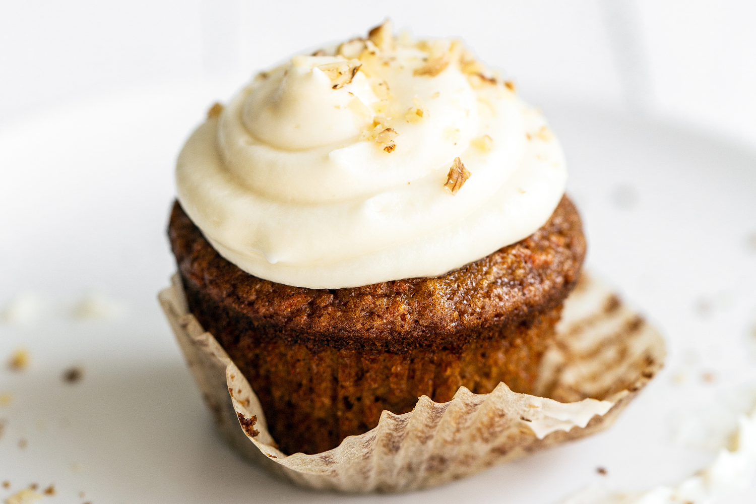Carrot Cake Cupcake with cream cheese frosting on a white background.