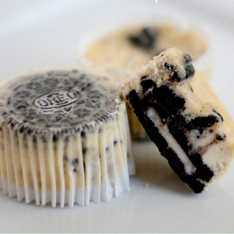 cookies and cream cheesecake cupcakes, with one cut in half to show the interior texture